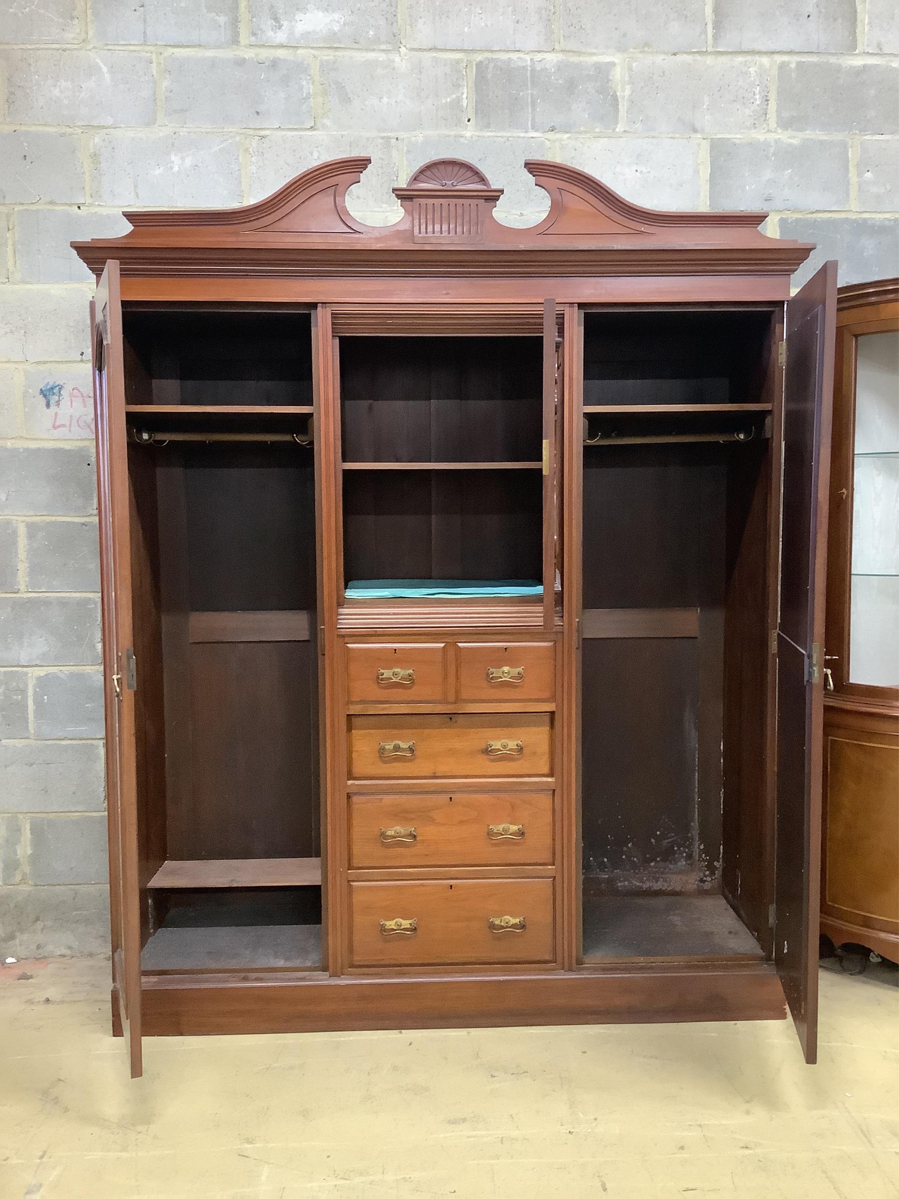 A late Victorian carved walnut mirrored compactum wardrobe, width 186cm, depth 56cm, height 227cm. Condition - good